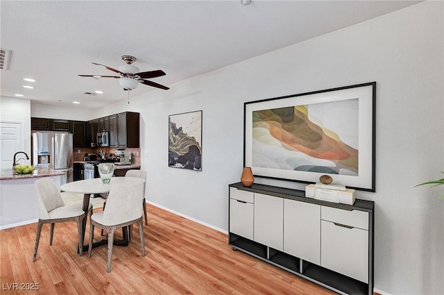 dining room with ceiling fan and light hardwood / wood-style flooring