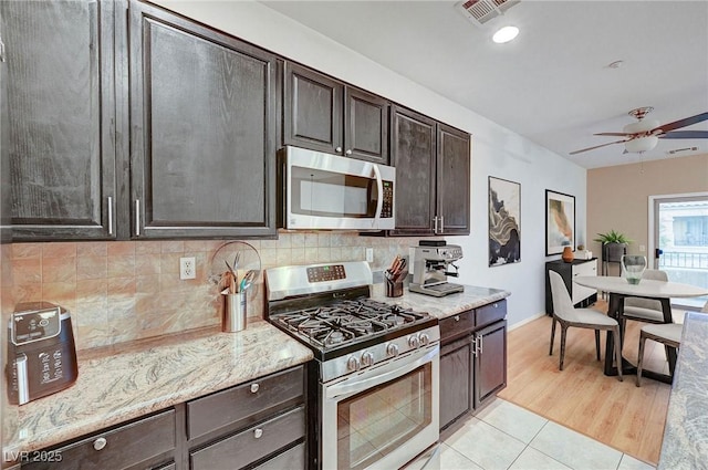 kitchen featuring decorative backsplash, dark brown cabinets, and appliances with stainless steel finishes