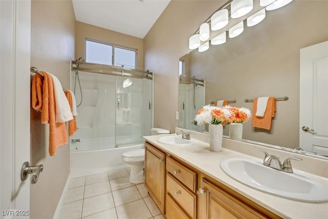 full bathroom featuring vanity, bath / shower combo with glass door, tile patterned floors, and toilet