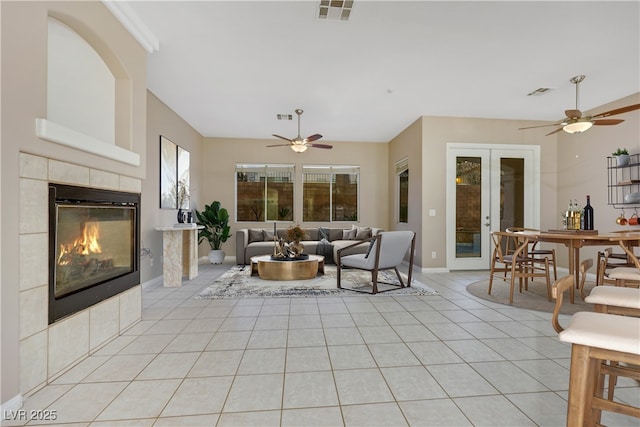 living area featuring light tile patterned flooring, french doors, visible vents, and a tile fireplace