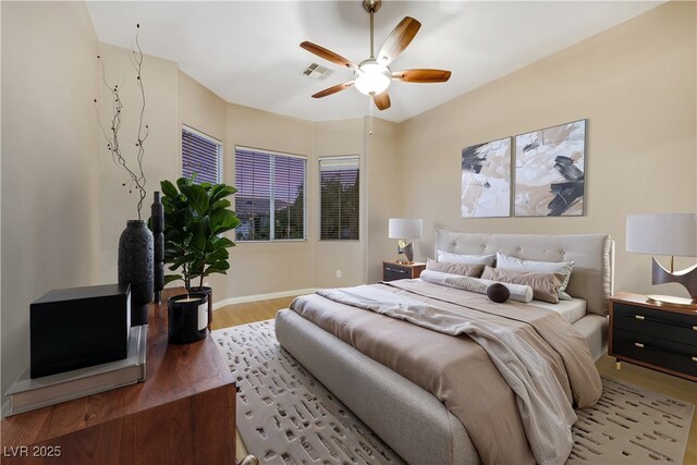 bedroom featuring visible vents, baseboards, ceiling fan, and light wood finished floors