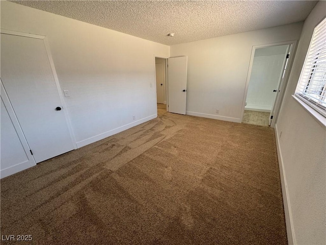 unfurnished bedroom featuring carpet, connected bathroom, and a textured ceiling