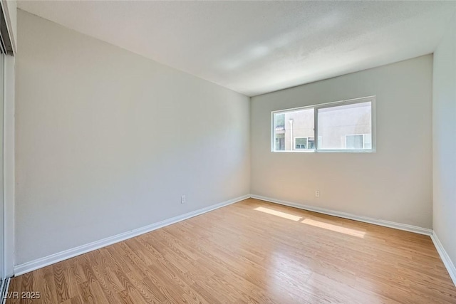 spare room with light wood-style flooring and baseboards