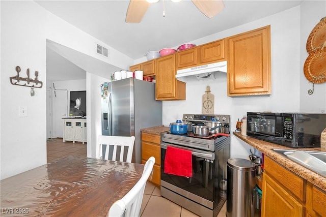 kitchen with visible vents, a ceiling fan, appliances with stainless steel finishes, tile patterned flooring, and under cabinet range hood