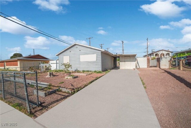 single story home with a gate, fence, and concrete driveway