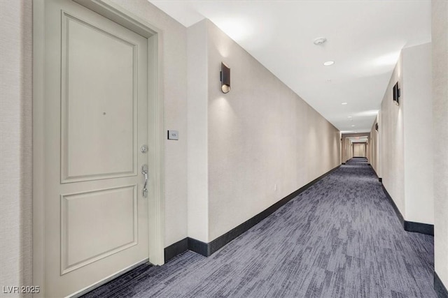 corridor featuring dark colored carpet