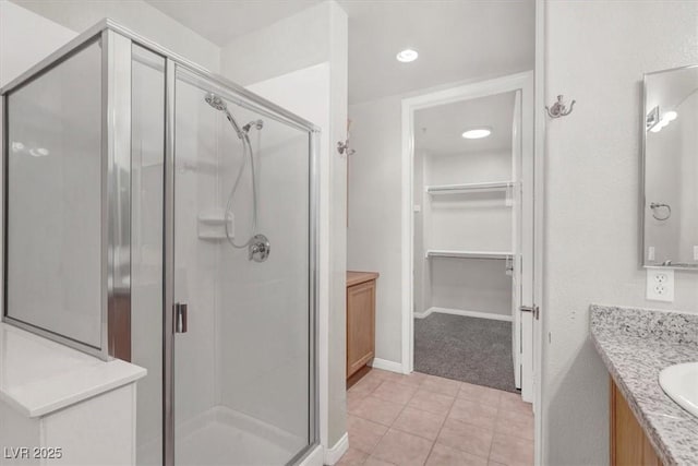 bathroom featuring vanity, a shower with shower door, and tile patterned floors