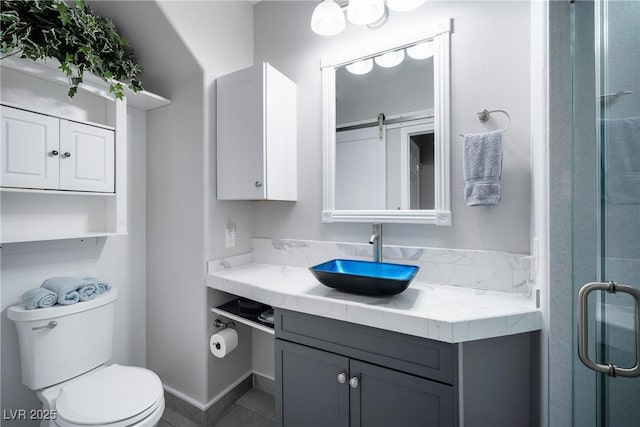 bathroom with a shower with door, vanity, and toilet