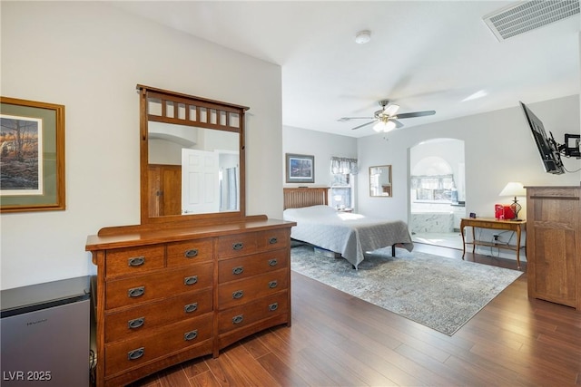 bedroom featuring ensuite bath and dark hardwood / wood-style floors