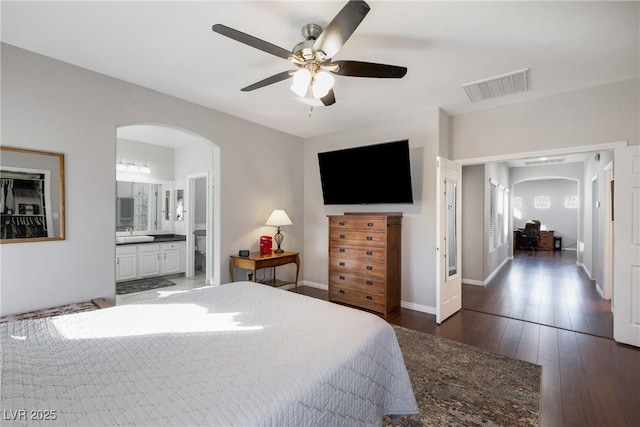 bedroom featuring ceiling fan, dark hardwood / wood-style floors, and ensuite bath