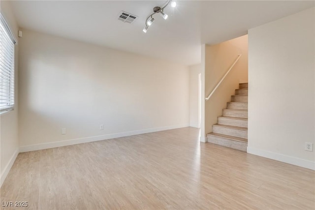 spare room featuring rail lighting and light wood-type flooring