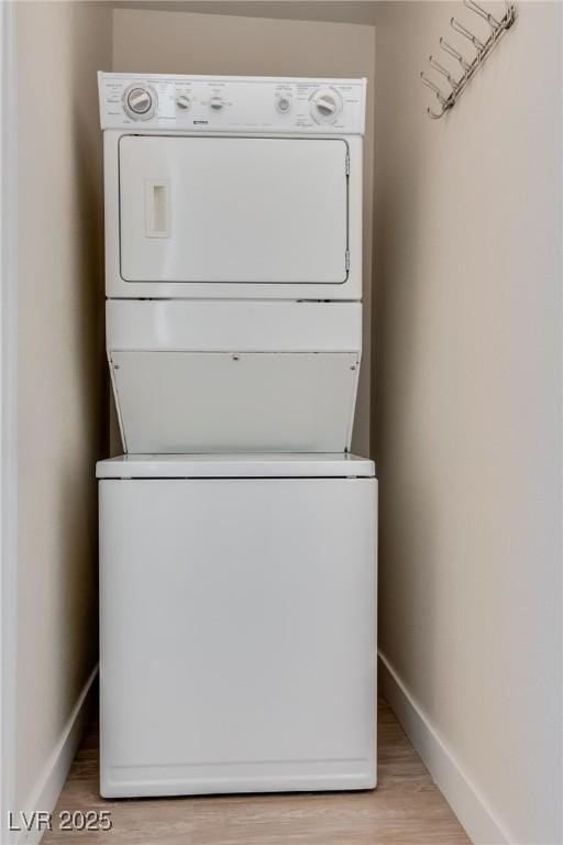 washroom featuring light wood-type flooring and stacked washer / dryer