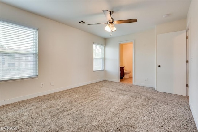 unfurnished bedroom featuring ceiling fan, ensuite bathroom, and light carpet