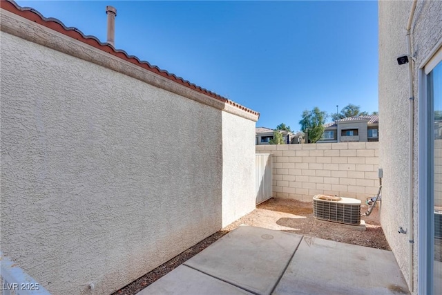 view of side of property featuring central AC and a patio area