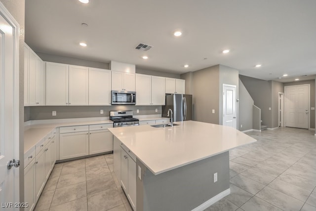 kitchen with stainless steel appliances, sink, a center island with sink, and white cabinets