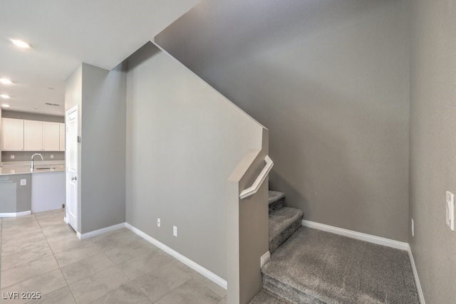 staircase featuring tile patterned flooring and sink