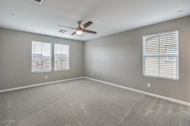 carpeted empty room with a ceiling fan, visible vents, and baseboards