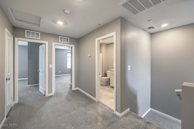 hallway featuring carpet floors and visible vents