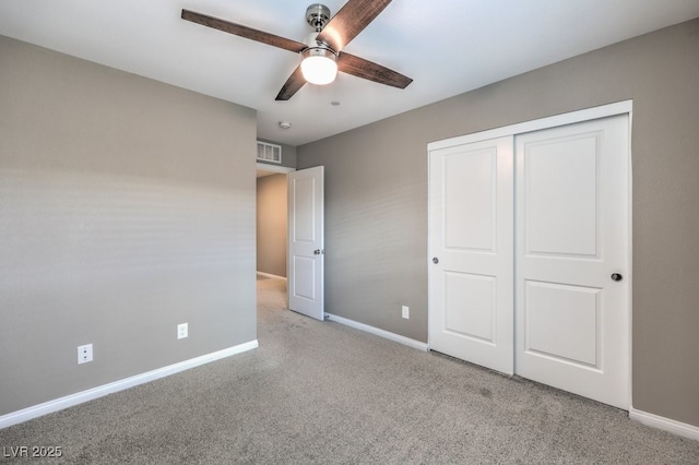 unfurnished bedroom featuring light colored carpet, ceiling fan, and a closet