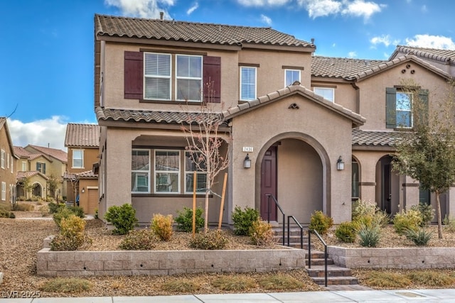 view of front of house with a tiled roof and stucco siding