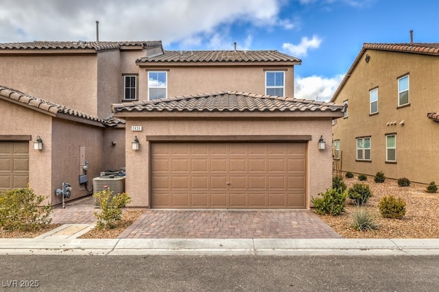 view of front of home featuring a garage, central AC unit, decorative driveway, and stucco siding