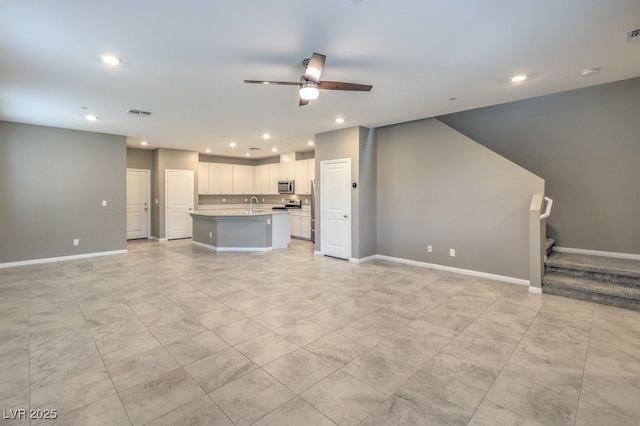 unfurnished living room featuring ceiling fan