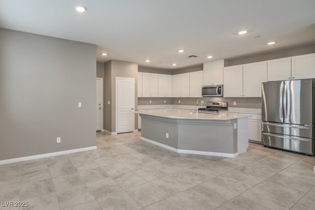 kitchen featuring white cabinetry, sink, stainless steel appliances, and an island with sink