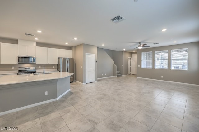 kitchen featuring sink, white cabinetry, light tile patterned floors, ceiling fan, and stainless steel appliances