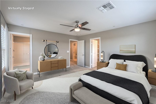 bedroom with baseboards, visible vents, ensuite bathroom, and light colored carpet