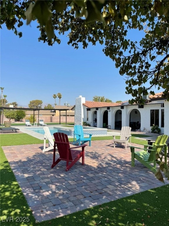 view of community with a patio, a swimming pool, and a lawn