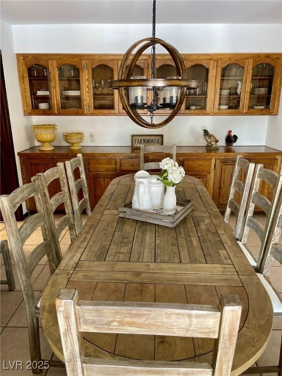 dining area featuring light tile patterned flooring and a notable chandelier