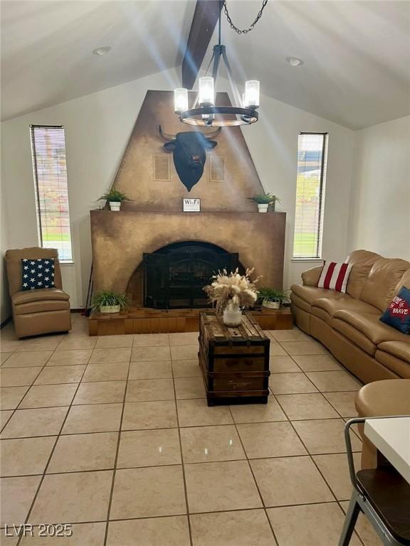 living room featuring vaulted ceiling with beams, a fireplace, and light tile patterned flooring