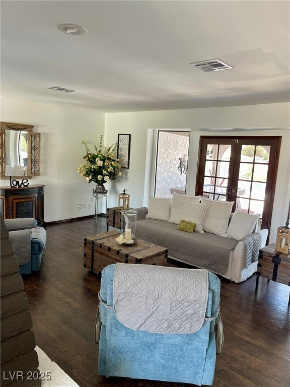 living room featuring french doors, a fireplace, wood finished floors, and visible vents