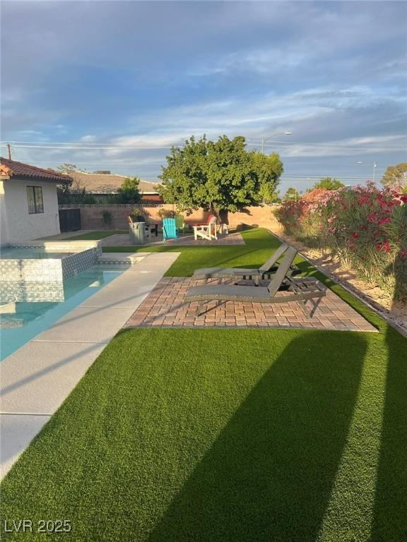 view of yard with fence, an outdoor pool, and a patio