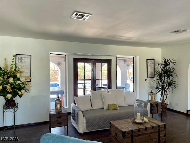 living room featuring baseboards, visible vents, and dark wood-style floors