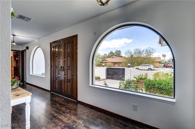 entryway with baseboards, wood finished floors, and visible vents