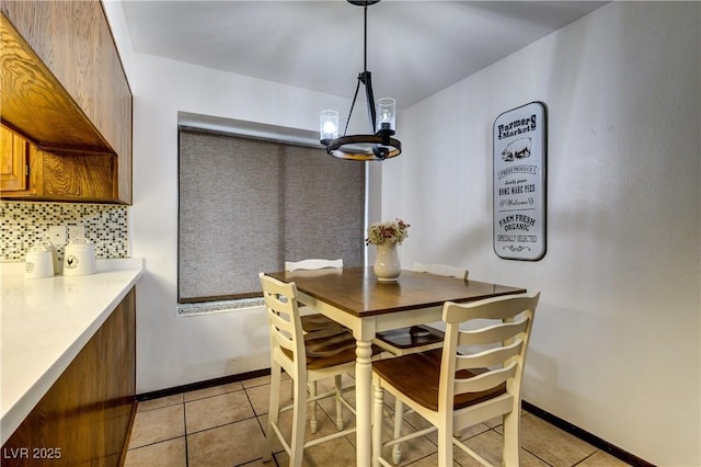 dining area featuring baseboards, an inviting chandelier, and light tile patterned floors
