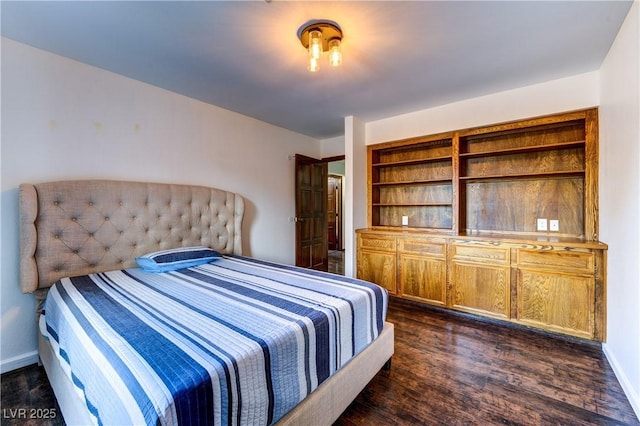 bedroom featuring baseboards and dark wood-type flooring
