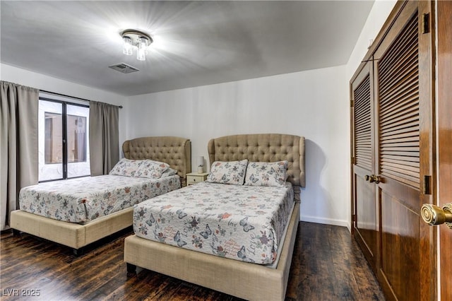 bedroom with baseboards, wood finished floors, and visible vents