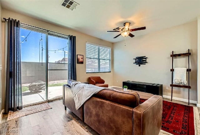 living room featuring wood-type flooring and ceiling fan