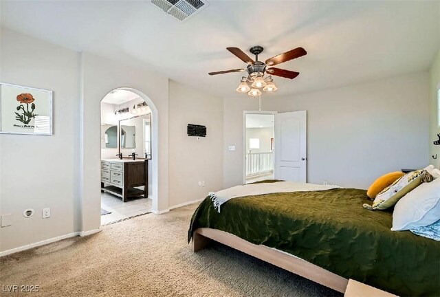 carpeted bedroom with ceiling fan and ensuite bath