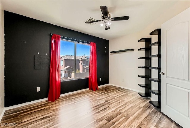 empty room featuring wood-type flooring and ceiling fan