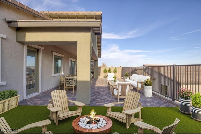 view of patio featuring an outdoor living space with a fire pit and fence