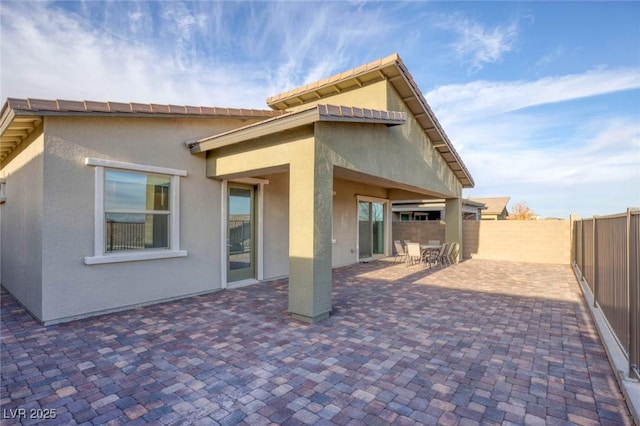 back of house with stucco siding, fence private yard, and a patio area