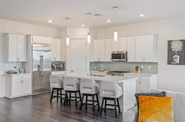 kitchen featuring white cabinets, a kitchen island with sink, and stainless steel appliances