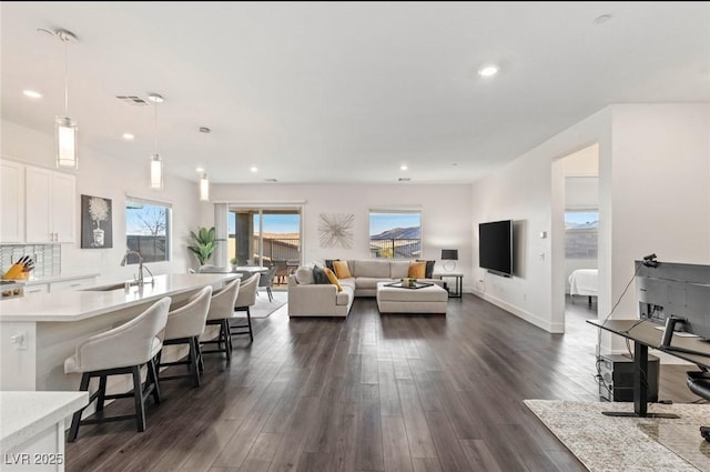 living area featuring dark wood finished floors, recessed lighting, and baseboards