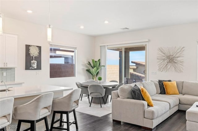 living area with recessed lighting, dark wood-style floors, and visible vents