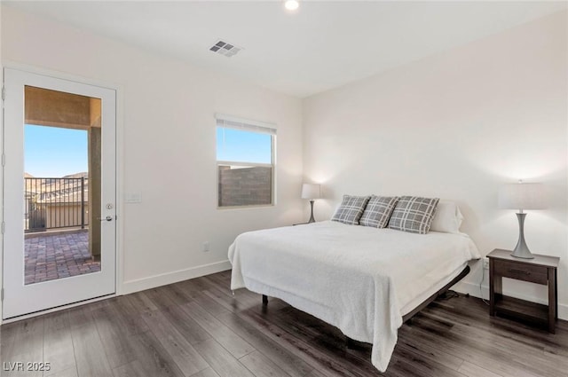 bedroom featuring visible vents, multiple windows, and wood finished floors