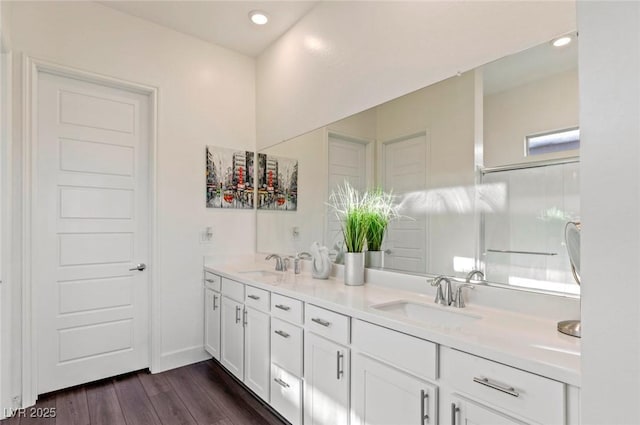 full bathroom with double vanity, recessed lighting, wood finished floors, and a sink