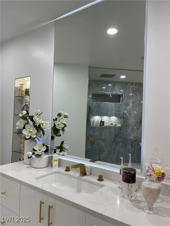 bathroom with vanity and tiled shower